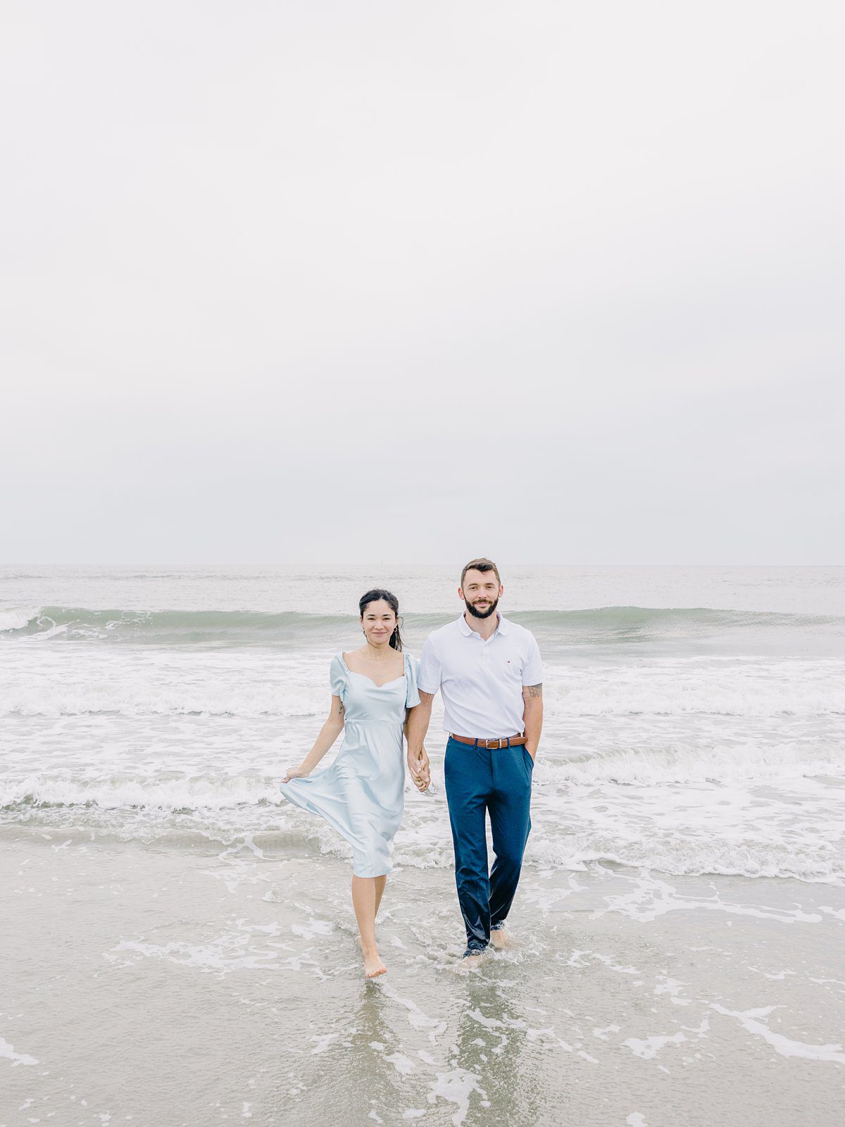 couple walking in the water at beach engagement session