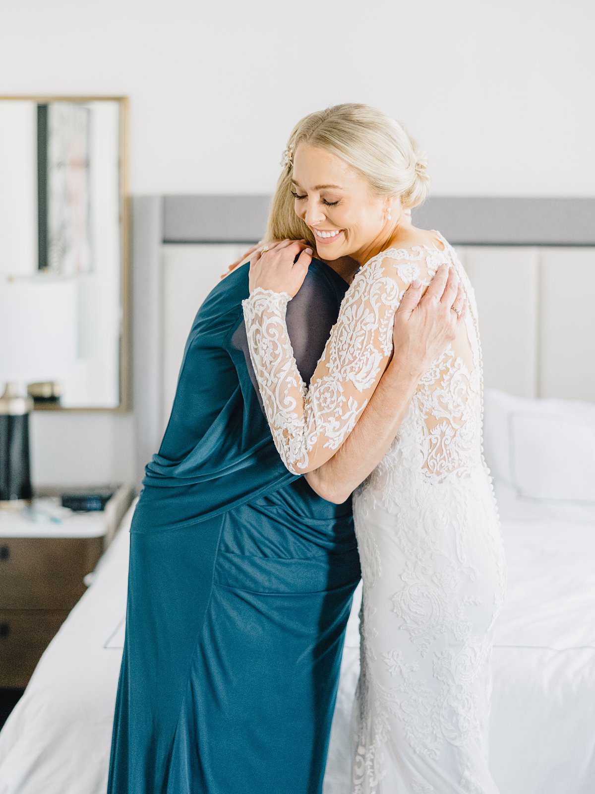 A bride hugs her mother while getting ready for her Mills House wedding