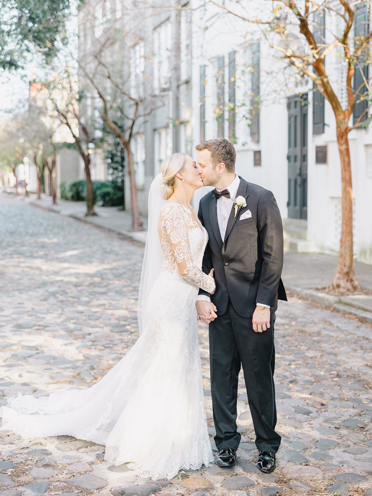 A bride and groom share a kiss on Chalmer's Street in downtown Charleston