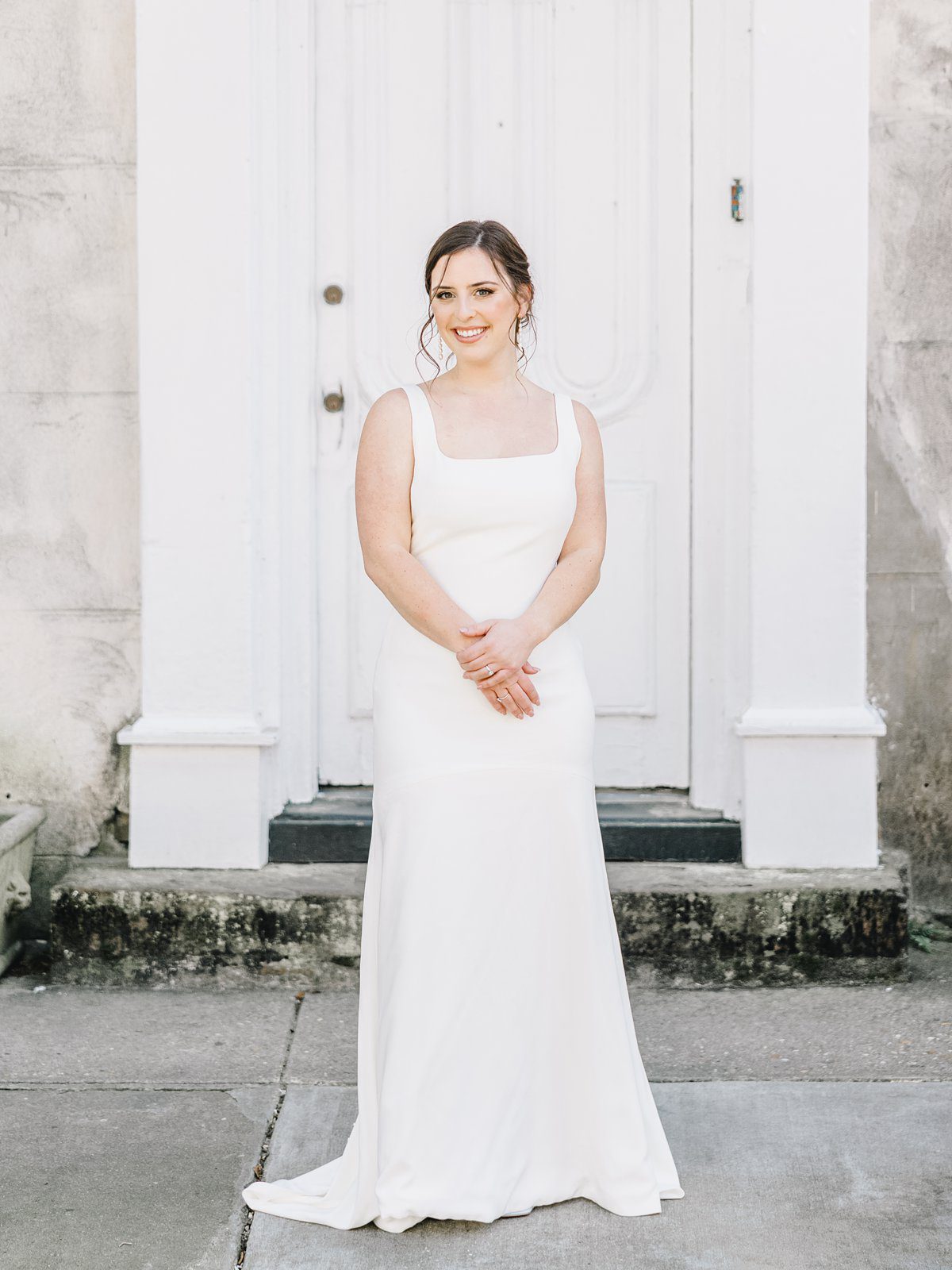 bride in simple white gown in downtown Charleston at her bridal session