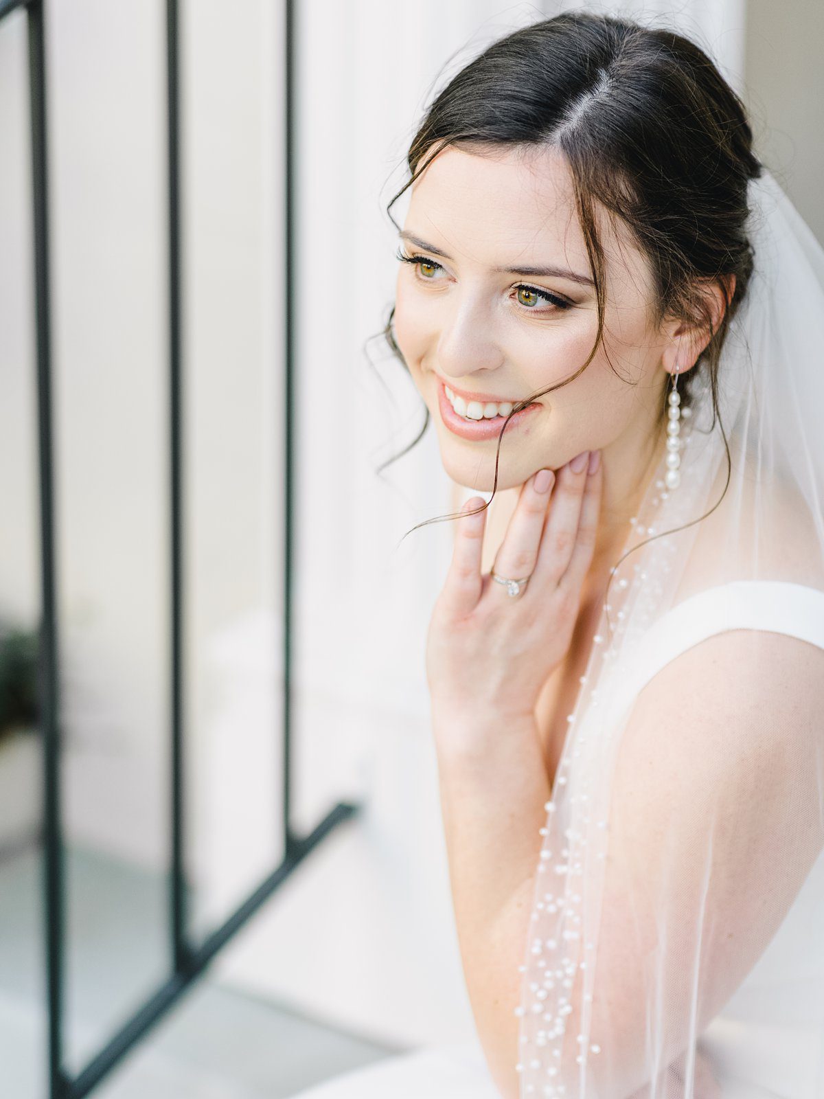 bride smiling on the steps in downtown Charleston at her bridal session