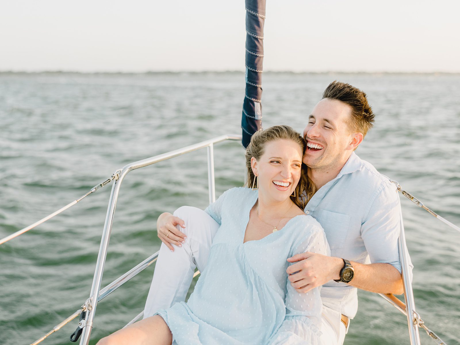 couple laughing sitting on a sailboat