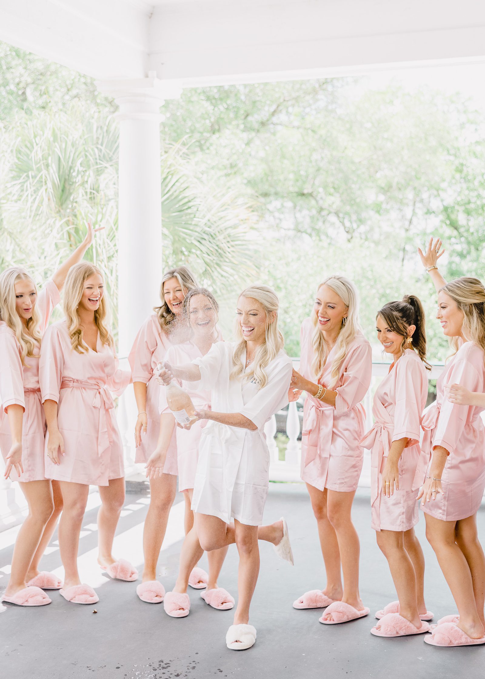 bridesmaids in pink robes pop champagne at Lowndes Grove wedding