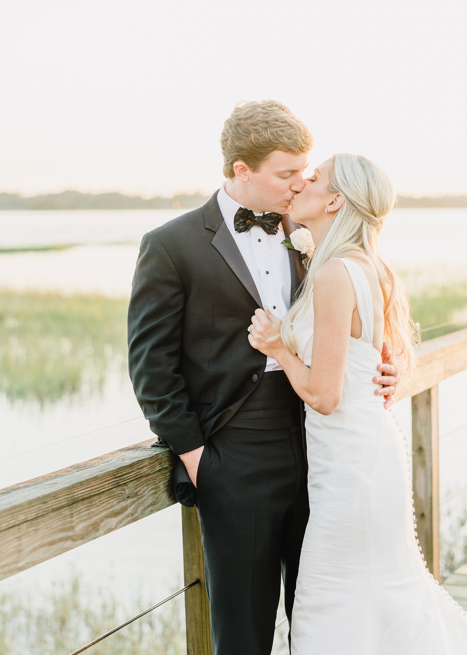 bride and groom share a kiss on the docks at Lowndes Grove wedding