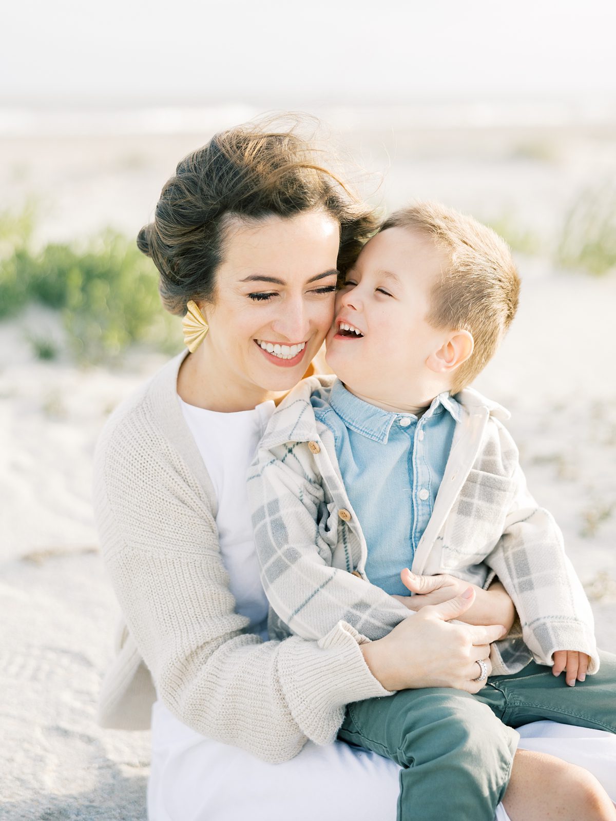 mother and son snuggling on the beach