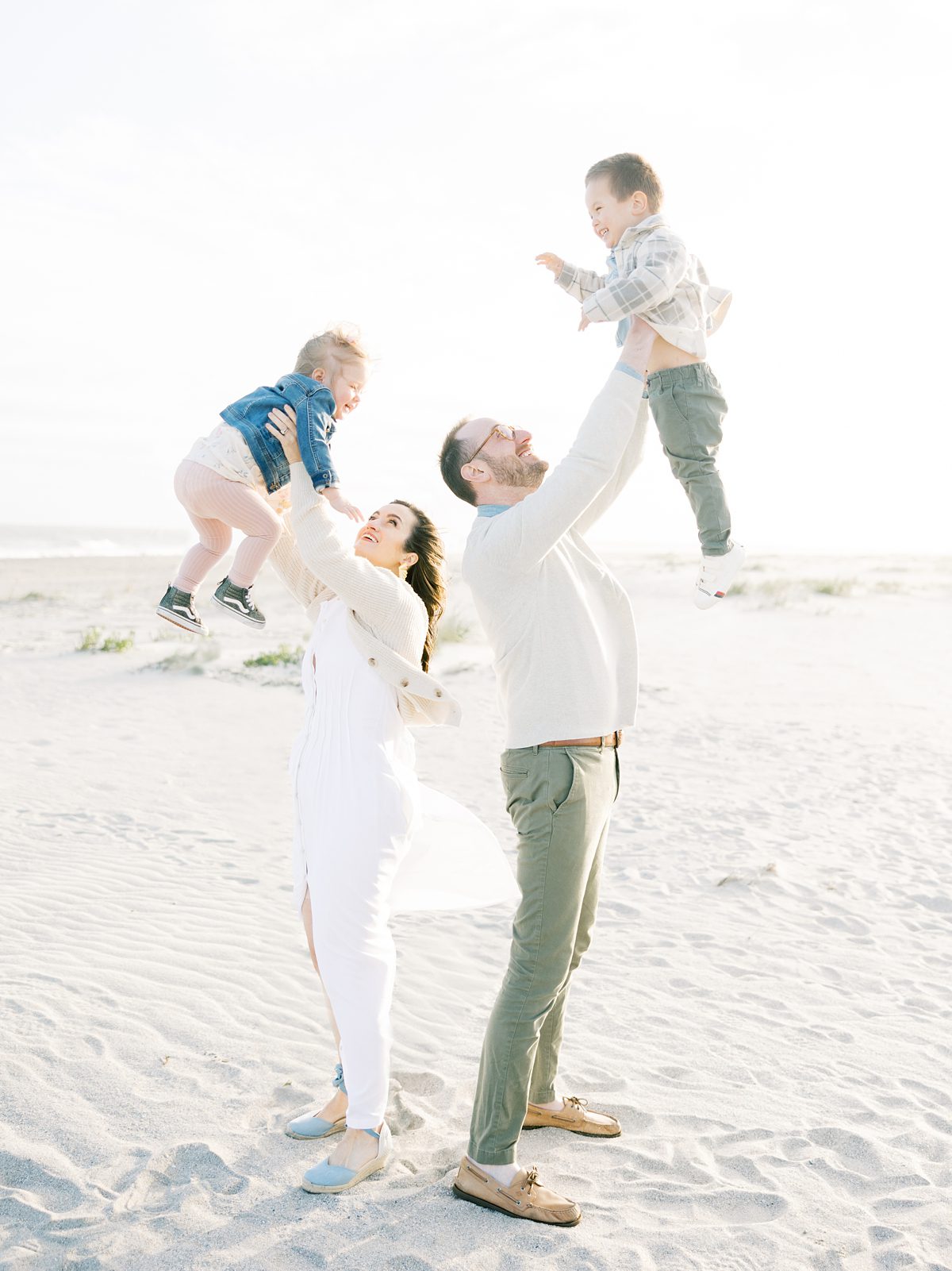 mom and dad play with their kids tossing them in the air