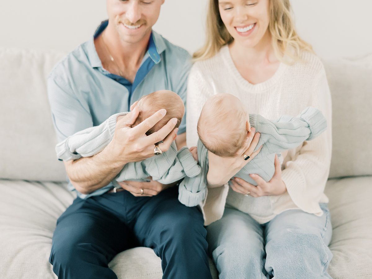 mom and dad cradle twin babies on the sofa at their in-home newborn session