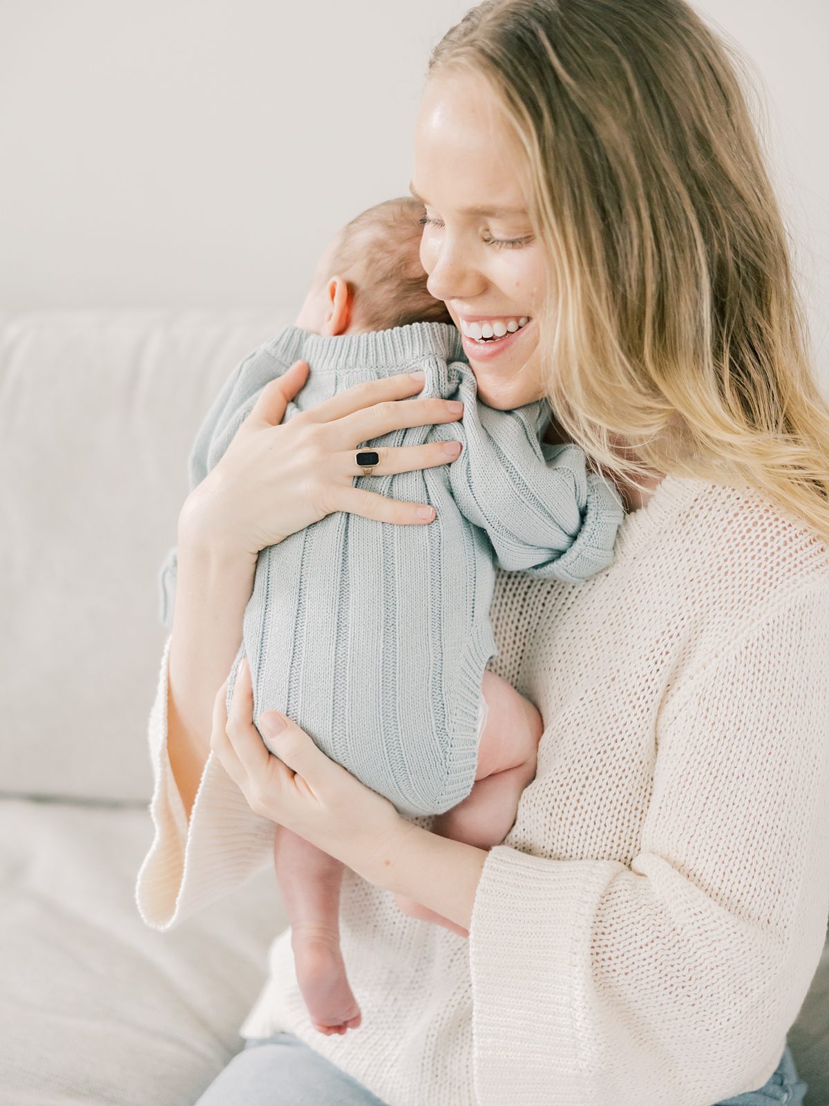 mom hold newborn baby girl up to her chest in a cuddle at their in-home newborn session